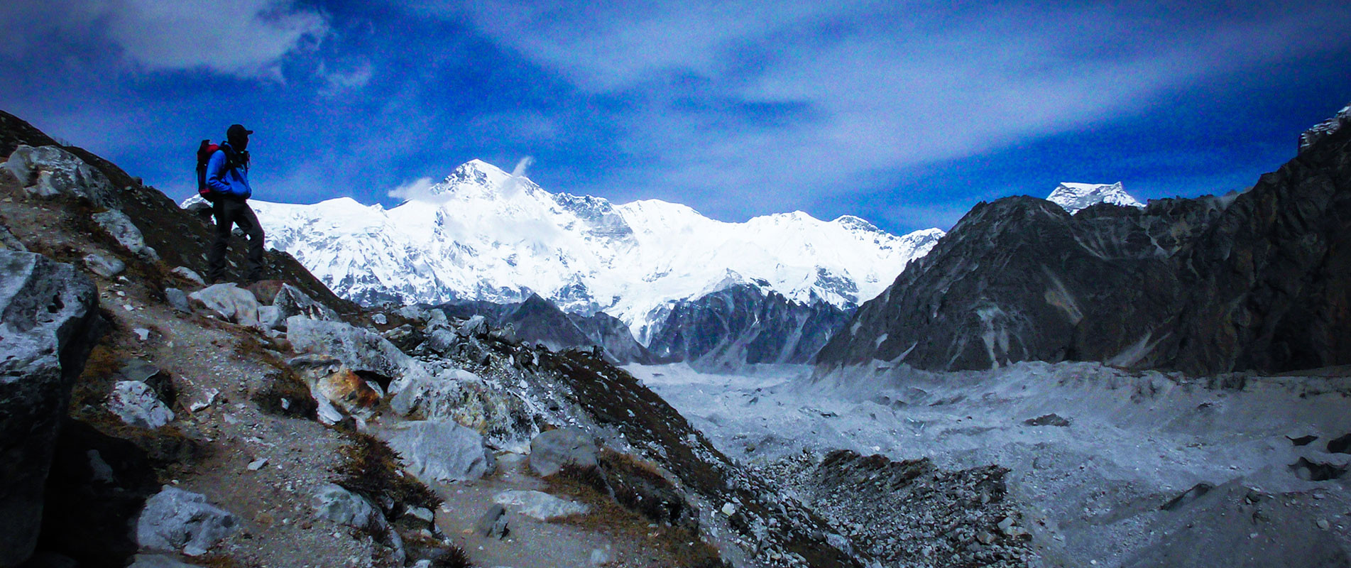 Trekker crossing Gojungba glacier on the way to Dragnag with Mount Cho-oyu and Gyachung Kang in the backdrop